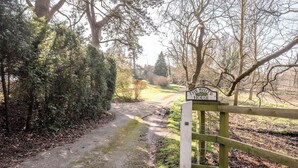 A sign for "The White House" in a rural setting with a gravel path leading through a wooded area. - Mulberry End, Foxhall (Foxhall)