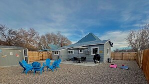 A house with a blue roof, a fenced backyard, and outdoor seating. - Baybeary Cottage, Bayfield base camp for Fun, Family & Adventure near Durango (Bayfield)