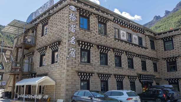 A traditional brick building with a balcony and a covered outdoor seating area. - Daocheng Yading Shiruo Hotel (Garze)