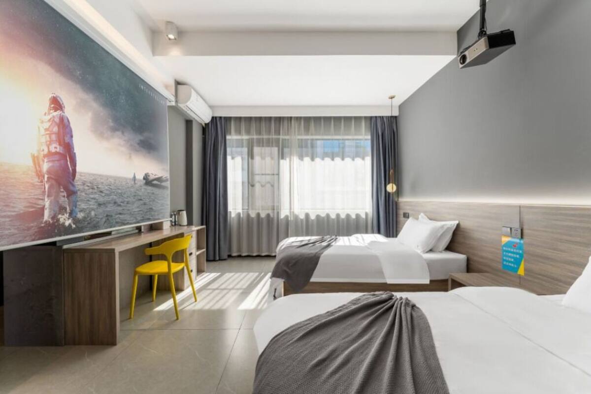 Una habitación de hotel con una cama grande, un escritorio, una silla y un televisor.