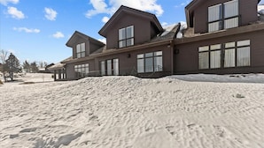 A two-story building with large windows and a snow-covered ground.