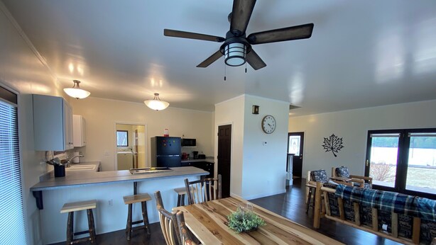 Una cocina amplia con una isla central, una mesa de comedor de madera y sillas.