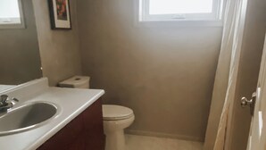 Un bagno piccolo con lavandino, WC e finestra.
