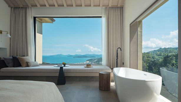 A modern bedroom with a large window, a bathtub, and a sofa with cushions. - Miyue Shenzhen Tianlu Secret Wild Wizard Holiday Hotel (Shenzhen)