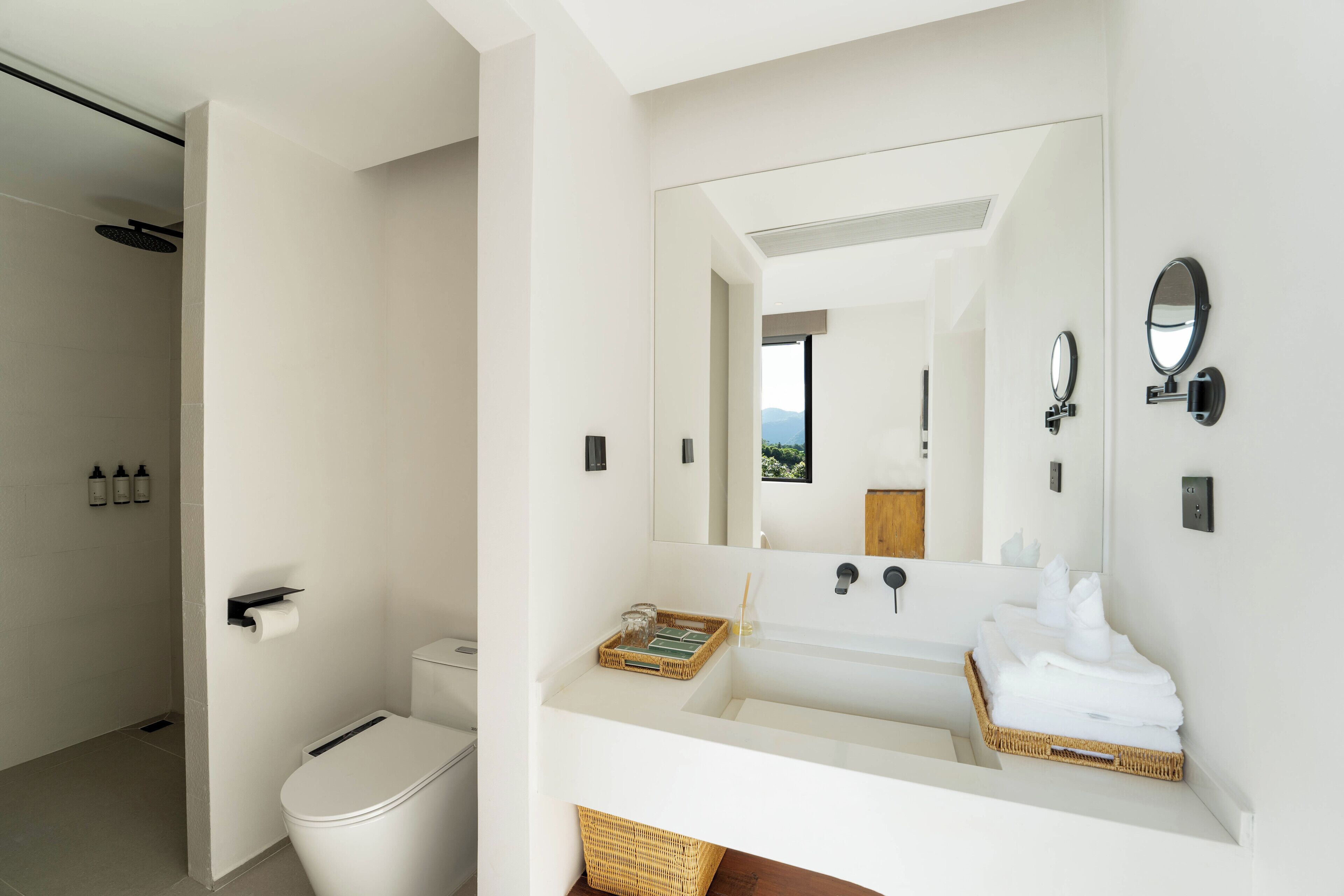 Une salle de bain moderne équipée de toilettes, d’un lavabo et d’une douche.