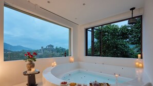 A modern bathroom with a large bathtub, a view of a cityscape, and candles. - Miyue Shenzhen Tianlu Secret Wild Wizard Holiday Hotel (Shenzhen)
