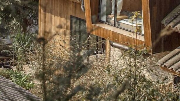 Een houten hut met een groot raam en een schuin dak.