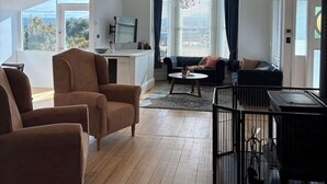 A spacious living area with a large chandelier, a sofa set, and a dining area. - Forest Rd Haven with Tamar River Views (Trevallyn)