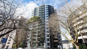 A multi-story building with a modern architectural design, featuring balconies on each floor. - Cozy Aircon Studio Nearby Skytower -Pool Sauna Gym (Auckland)