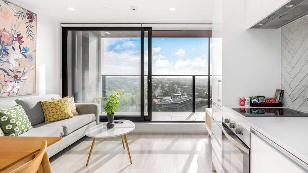A modern apartment with a balcony, a kitchen with a built-in oven, and a dining area with a table and chairs. - Incredible View Aircon 1B Studio Auckland Central (Auckland)