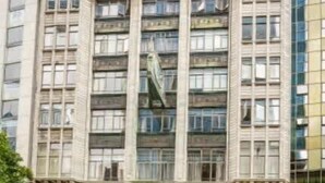 A multi-story building with a classical architectural style, featuring large windows and a central entrance.