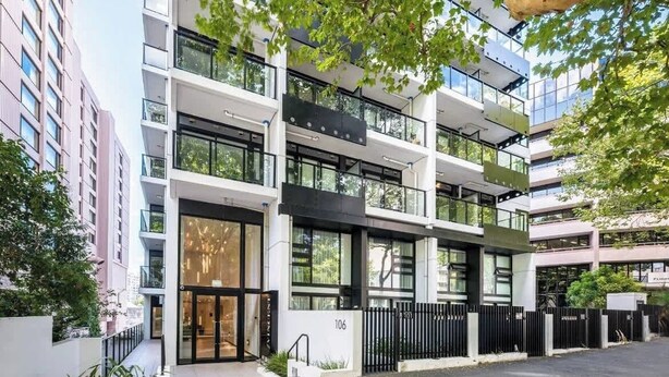 Un immeuble à plusieurs étages doté d’une architecture moderne, caractérisé par de grandes fenêtres et des balcons.