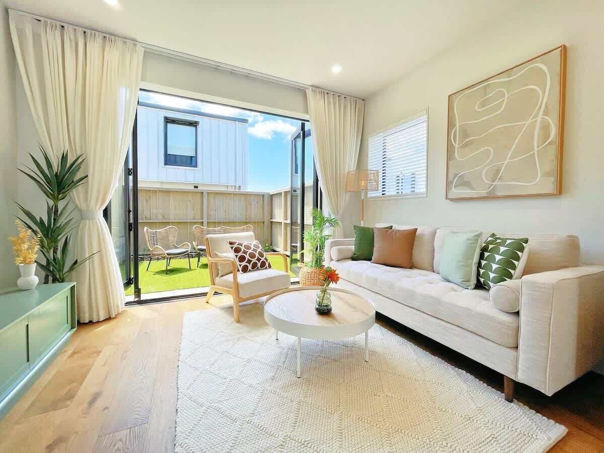 Una sala de estar moderna con sofá, mesa de centro y vistas al exterior.