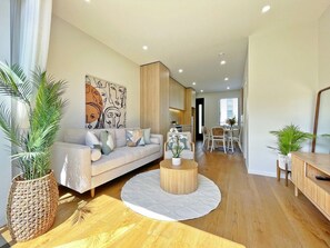 A modern living room with a sofa, coffee table, and plants.
