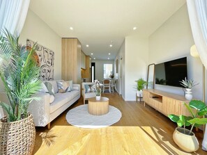 Ein modernes Wohnzimmer mit Sofa, Couchtisch und Fernsehschrank.