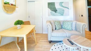 Ett modernt vardagsrum med en soffa, ett matbord och ett soffbord.