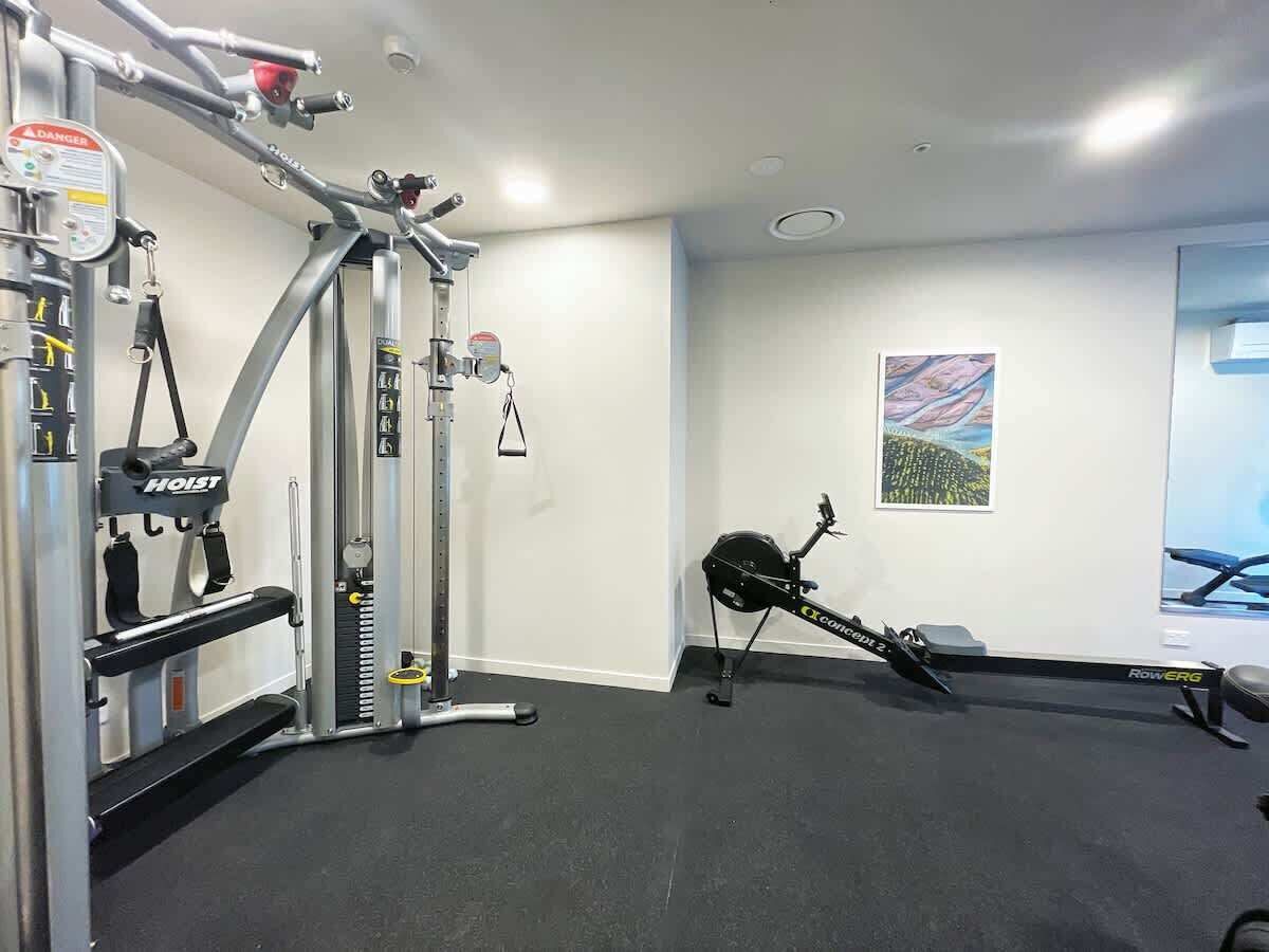 Ett gym med en roddmaskin, en viktbänk och en kabelmaskin.