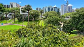 A cityscape with modern buildings, a prominent tower, and lush greenery.