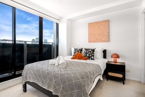 A modern hotel room with a large bed, a city view, and a minimalist decor. - Incredible City & Skytower View Near Queen St-Pool (Auckland)