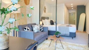 A modern bedroom with a bed, a sofa, and a coffee table.