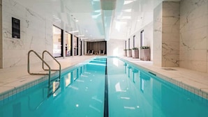 An indoor swimming pool with clear water, marble walls, and a modern ceiling design. - Stunning & Bright Studio in Central -Swimming Pool (Auckland)