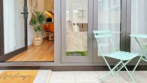 Ein modernes Interieur mit einer Schiebetür zum Küchenbereich, einer kleinen Sitzecke mit Tisch und Stühlen sowie einer Fußmatte.