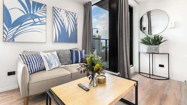 A modern living room with a sofa, coffee table, and artwork.