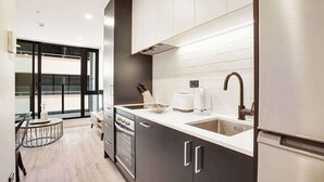 A modern kitchen with a large window, a built-in oven, and a refrigerator. - Stunning Studio Close to SkyTower - Pool Gym Sauna (Auckland)