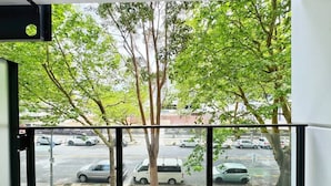 A balcony with a view of parked cars and trees. - Central Location Cozy Studio with Pool Gym & Sauna Nearby Skytower (Auckland)