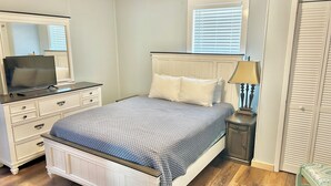 A bedroom with a bed, dresser, TV, lamp, and window. - Charming 2-bedroom cottage, sleeps 2-4, with WiFi & AC in adorable Guntersville (Guntersville)