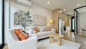 A modern living room with a sofa, coffee table, and a large mirror.