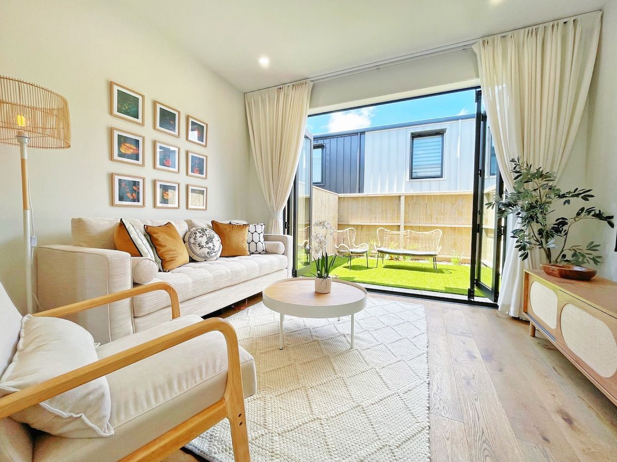 A modern living room with a sofa, coffee table, and a view of a balcony.