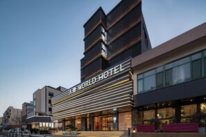 Un hotel moderno con un letrero llamativo que dice 'WORLD HOTEL'.