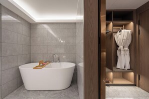 A modern bathroom with a freestanding bathtub, a vanity with a mirror, and a robe hanging on a rack. - WorldHotel Quancheng Sqr Kuanholi Branch (Jinan)