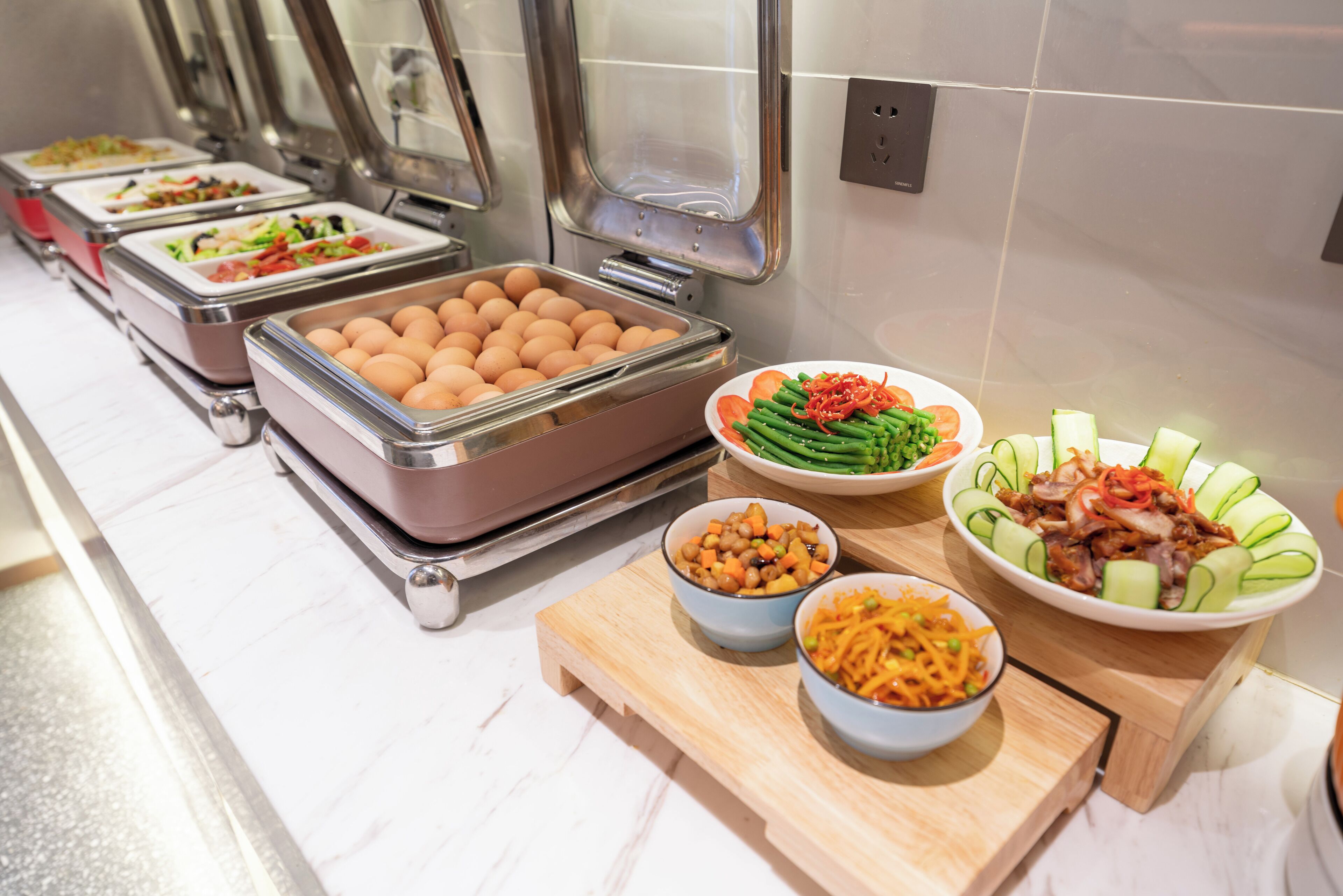 Ein Buffet mit verschiedenen Speisen, darunter Eier, Gemüse und Salate.