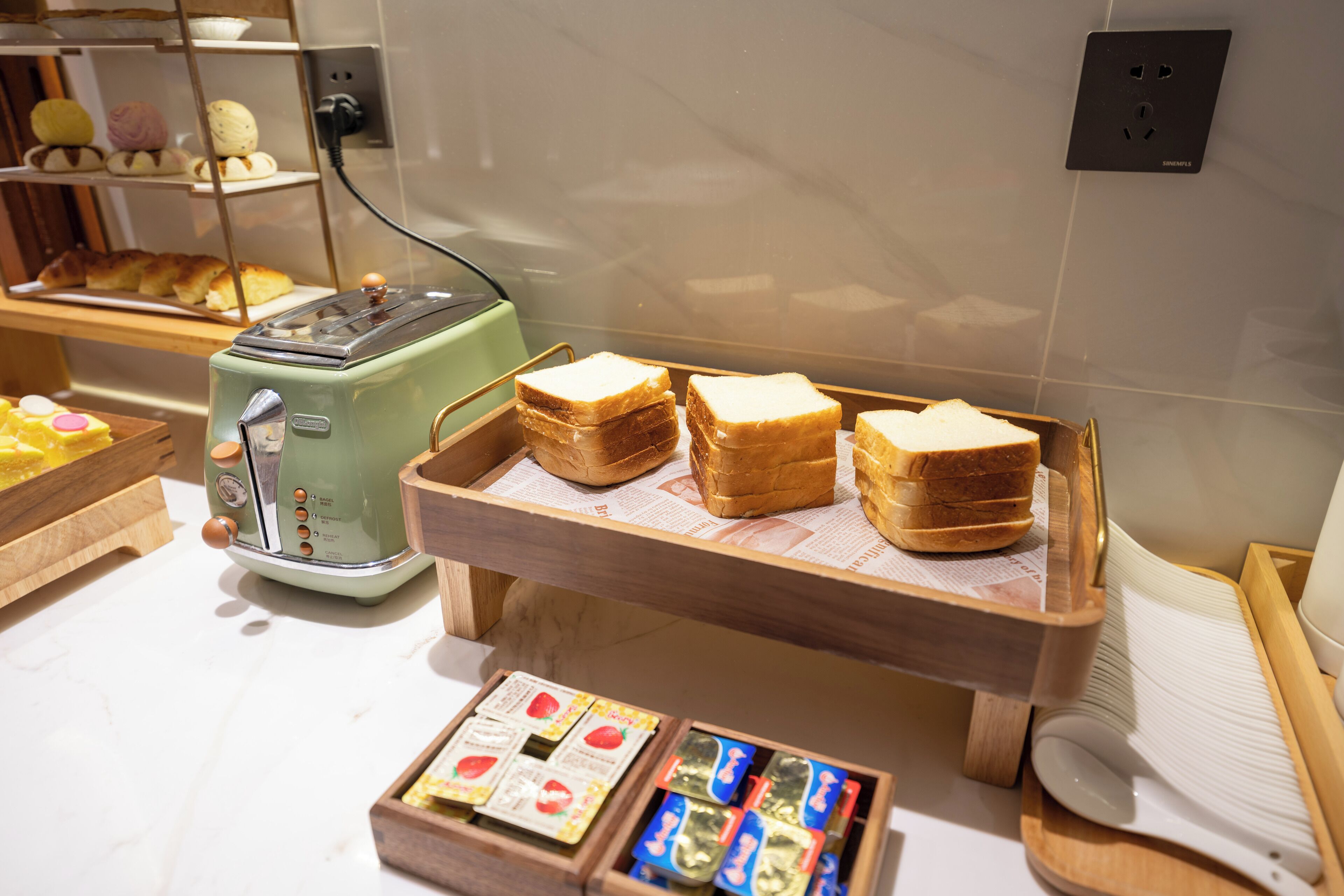 Un plateau de petit-déjeuner comprenant un grille-pain, du pain et une sélection de viennoiseries.