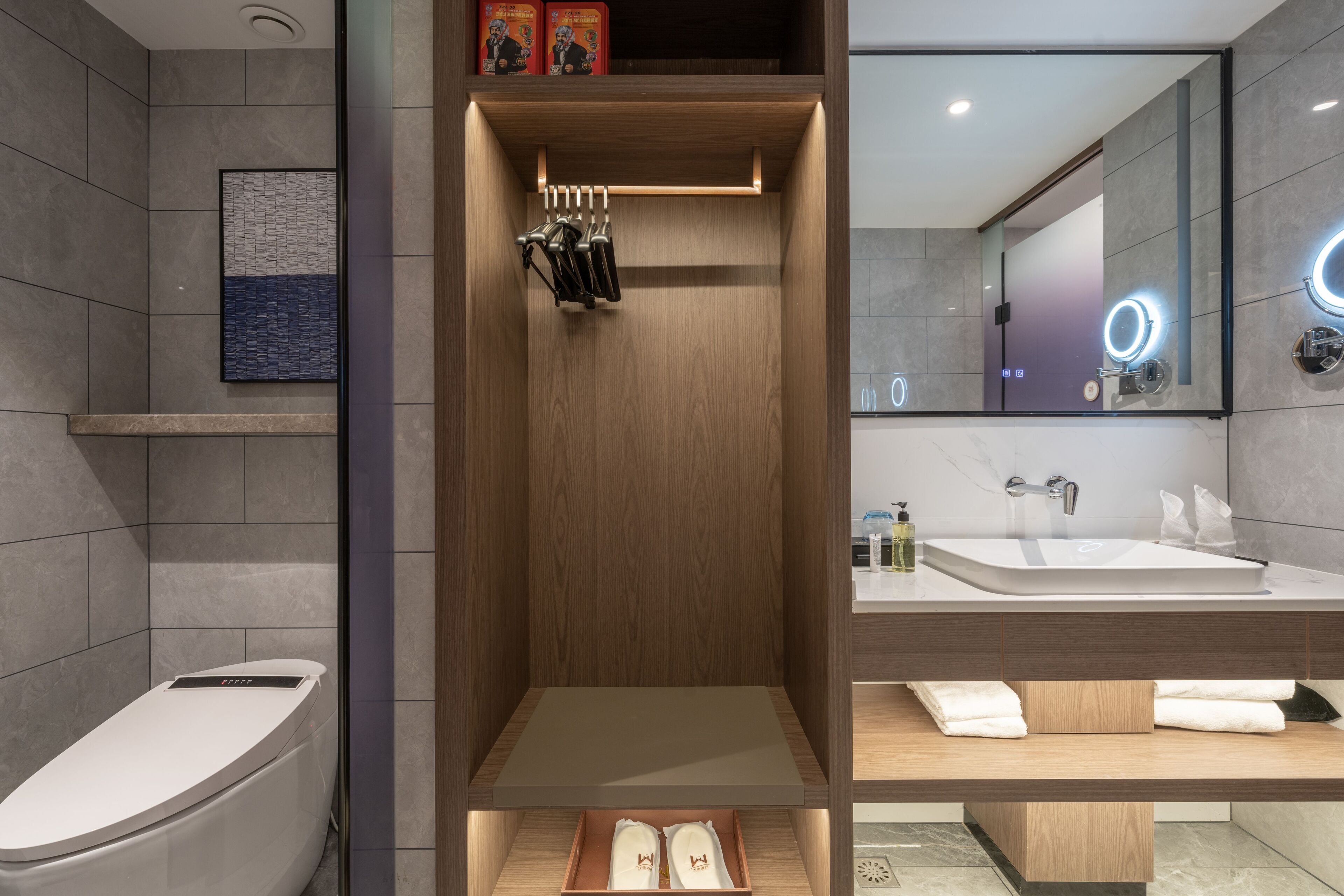 Een moderne badkamer met een douche, toilet en wastafel.