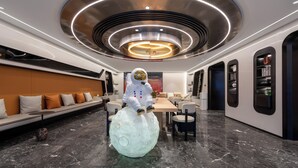 A modern interior with a round table, seating, and a unique spherical sculpture. - WorldHotel Quancheng Sqr Kuanholi Branch (Jinan)