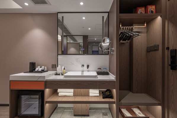 A modern bathroom with a double sink, a mirror, and a towel rack.