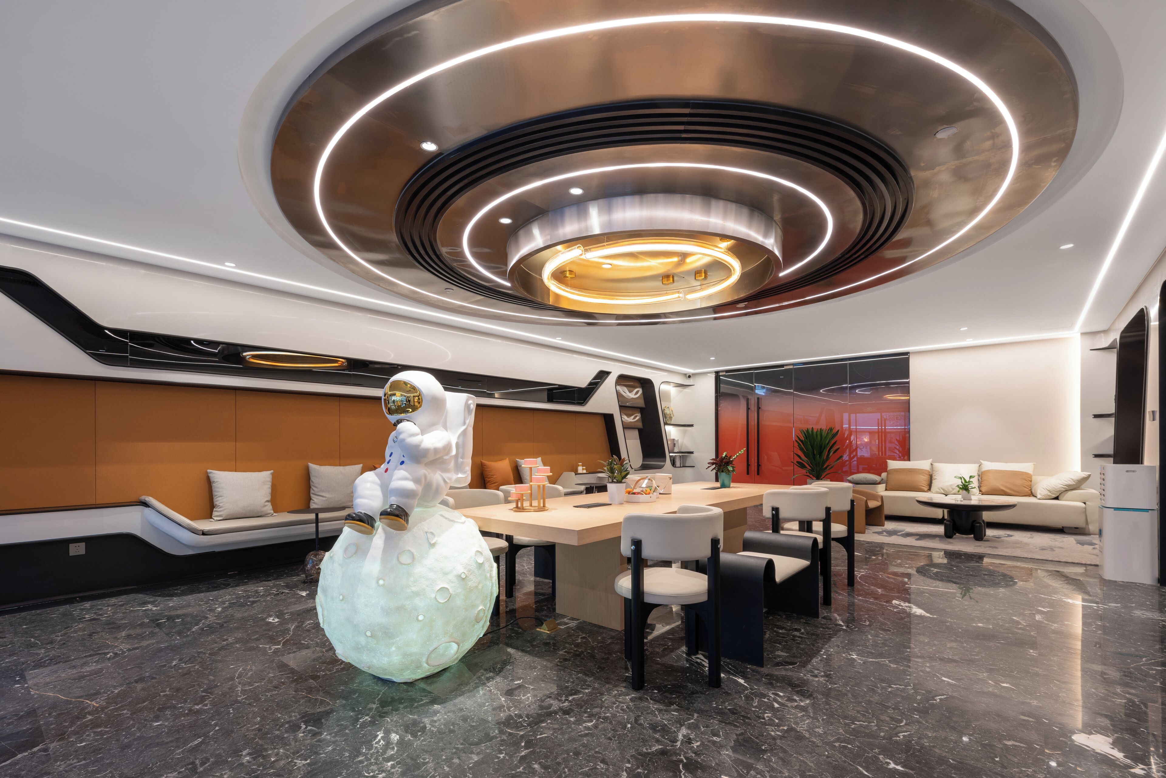 Un interior moderno con una zona de comedor central, distribuciones de asientos y un diseño de techo distintivo.