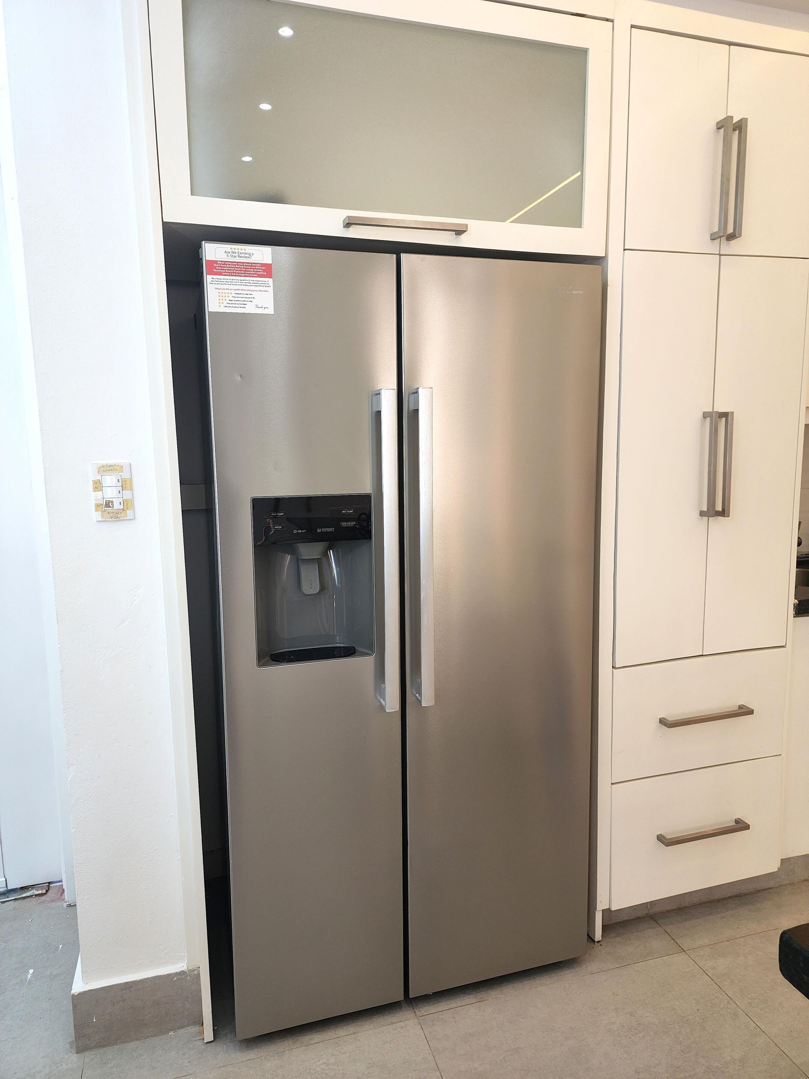 Un refrigerador de acero inoxidable con dispensador de agua, puertas dobles y compartimento congelador.