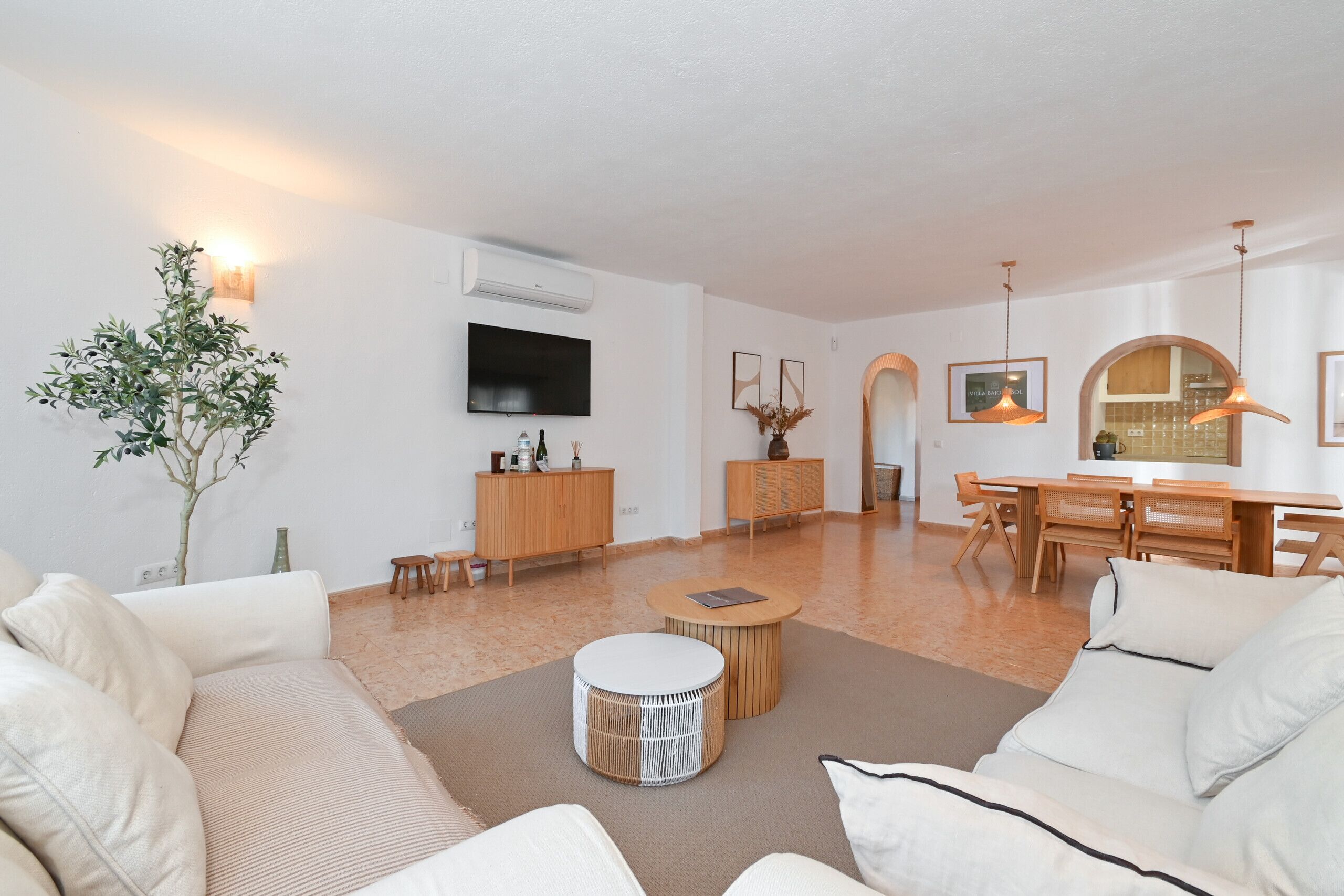 Un salon moderne avec un canapé, une table basse et un coin repas.