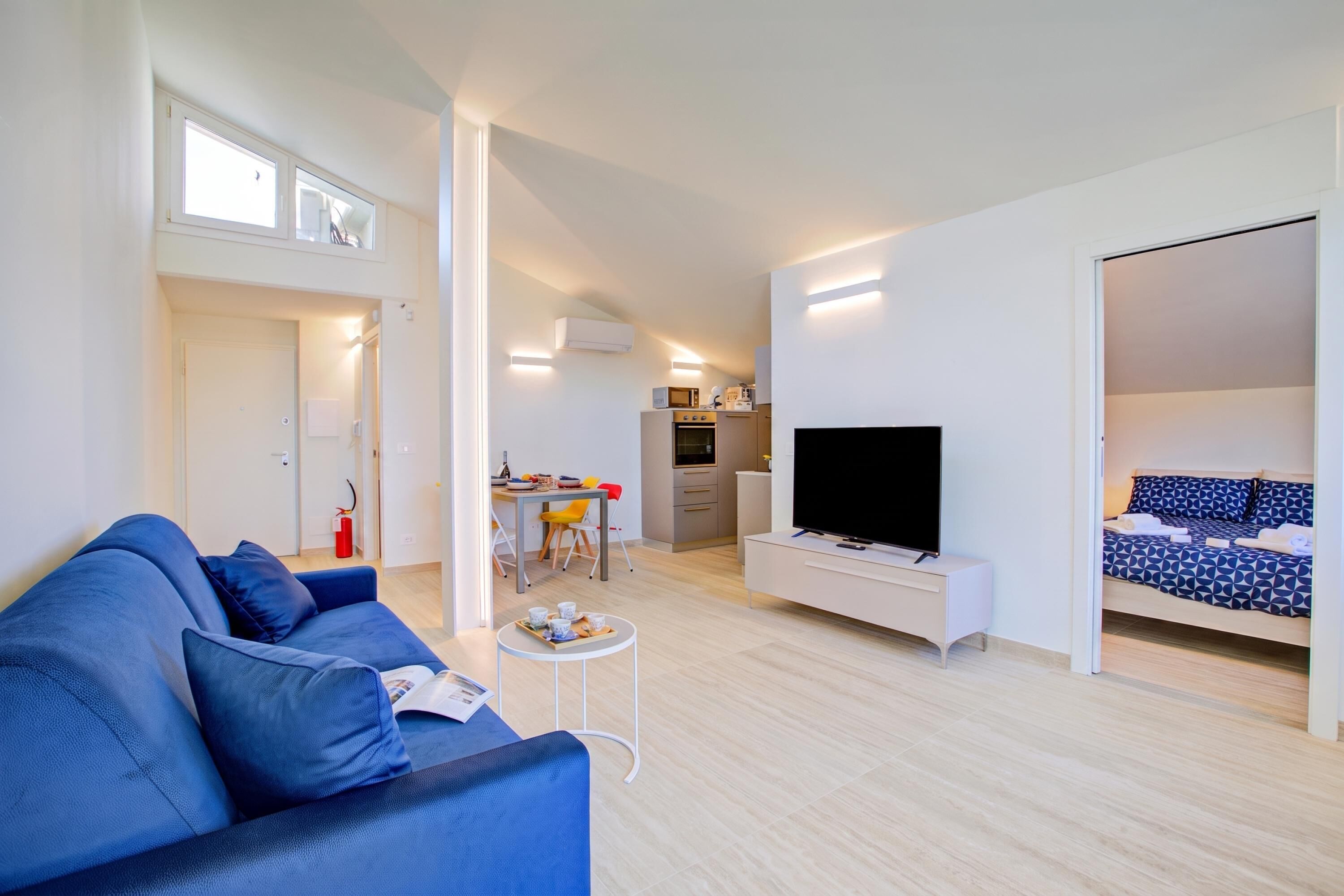 Un apartamento moderno con sala de estar, kitchenette y dormitorio.