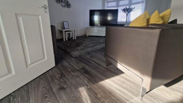 Un salon avec un canapé, un téléviseur et une petite table.