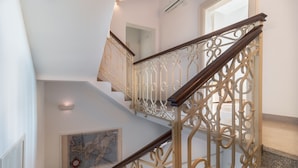 Un escalier orné de rampes en métal ouvragé et doté d’une main courante en bois.