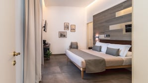 Une chambre d’hôtel moderne équipée d’un lit, d’une table de chevet et d’un petit coin salon.