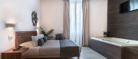 A modern bedroom with a bed, bedside table, and a built-in bathtub.