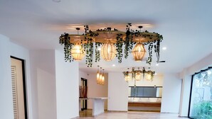 A spacious, modern interior with a polished marble floor, a central area with a reception desk, and hanging wicker lamps. - Town Center Zama Condo Hotel by Marea (Tulum)