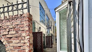 A narrow cobblestone street flanked by historic buildings with brick facades and metal gates. - Downtown, Roof Deck, Fireplace (Saugatuck)