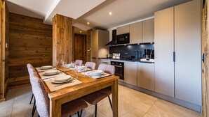 A modern kitchen with a dining area. - 6-person flat in a new residence on the snow front (LA TOUSSUIRE)